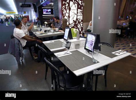 Airport passengers dine at airport restaurant in airport terminal where ...