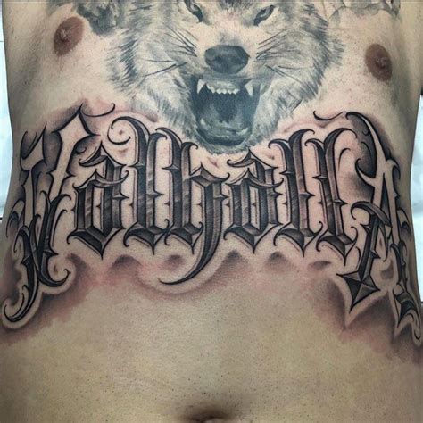 a man's chest with a wolf tattoo on it and the word wild written in cursive font