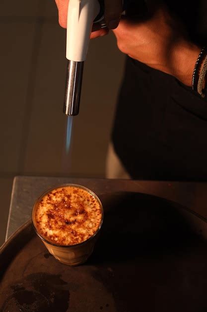 Premium Photo | Burning crème brûlée with a blowtorch. burnt sugar on ...