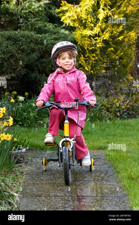 Young girl with a safety hat on riding a tricycle hi-res stock photography and images - Alamy