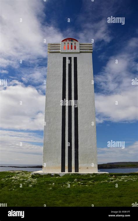 The lighthouse at Kalfshamarsvik on peninsula Skagi in Iceland. A white tower with three black ...