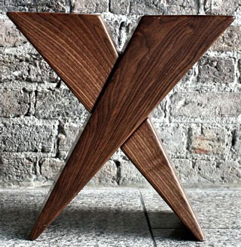 a wooden object sitting on top of a stone floor next to a brick wall in the shape of an x