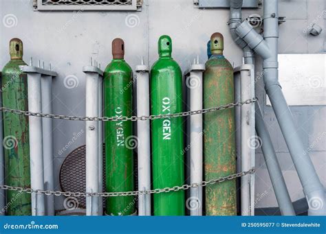 Compressed Gas Cylinders Being Stored Vertically Secured by a Metal Chain and a Metal Cap. Stock ...