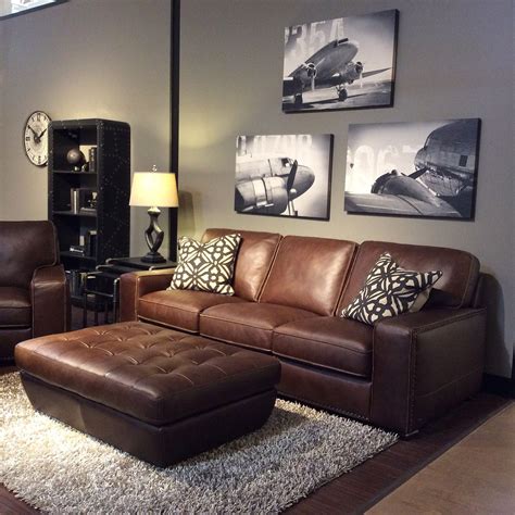 Family room with warm gray walls, black and white art, brown leather furniture, o… | Brown ...