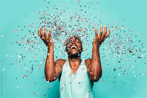 "Cheerful Black Ethnic Man Throwing Confetti On Air." by Stocksy Contributor "VICTOR TORRES ...