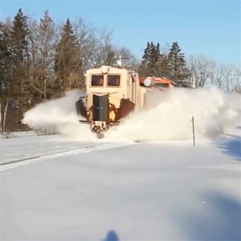 Trains with snow plows turn snow into white tidal waves