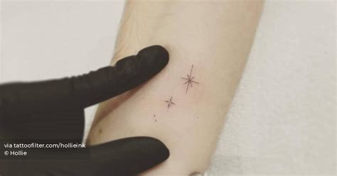 Tiny stars tattooed on the inner forearm, minimalistic