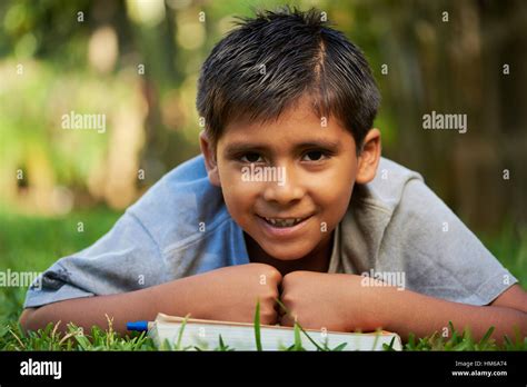 kid smiling and laying down on a book at the park Stock Photo - Alamy