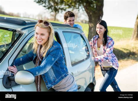 Vehicle breakdown young people pushing car down the road Stock Photo ...