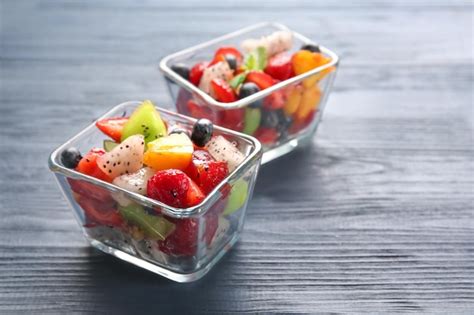 Premium Photo | Dessert bowls with delicious fruit salad on wooden table