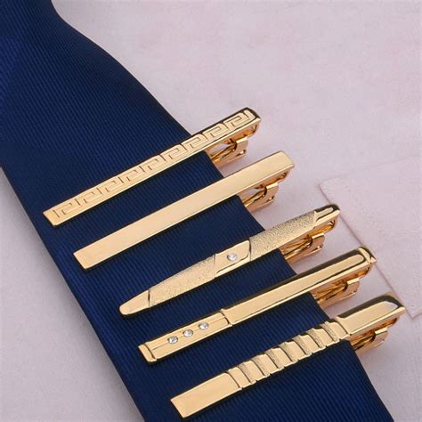 four different types of gold hair clips on a blue tie