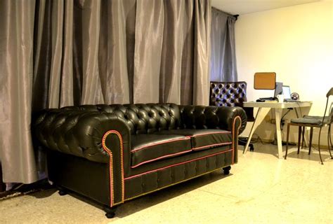 a black leather couch sitting next to a table