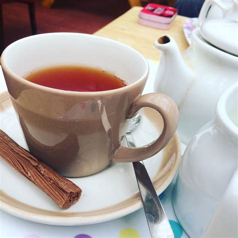 a cup of tea on a saucer with cinnamon sticks