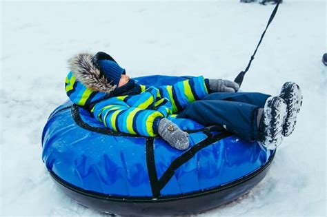 Premium Photo | Little kid in snow tube winter time