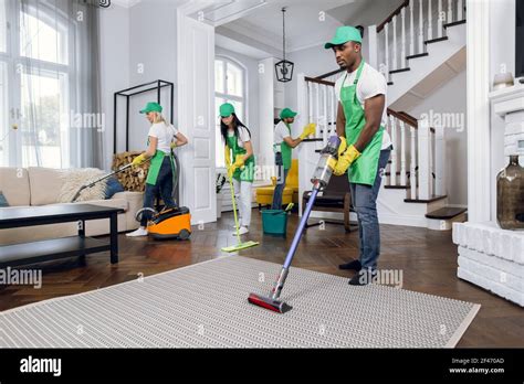 Group of four multiracial people cleaning client house Stock Photo - Alamy