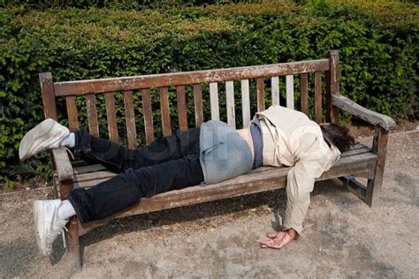 Homeless unemployed man sleeping on bench in Parisian park at springtime. | Stock Photo | Colourbox