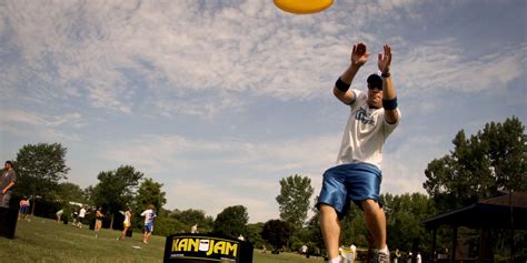 a man is jumping up to catch a frisbee in the air with his hands