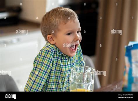 Kid with his mouth open leaning on the kitchen table Stock Photo - Alamy