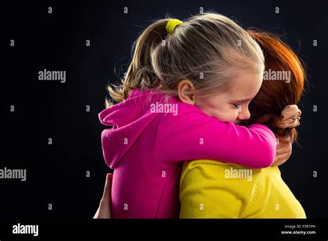 Little girl hugging her mother smiling over grey background Stock Photo - Alamy