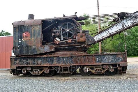 an old rusty train sitting on top of gravel