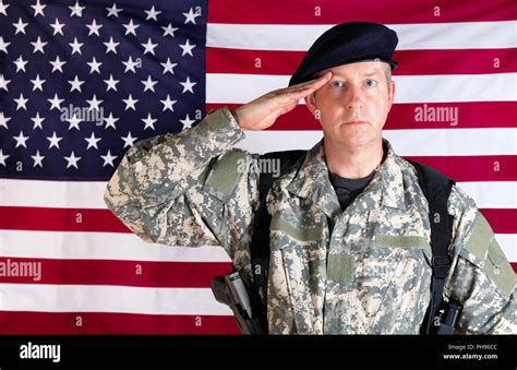 Veteran solider saluting with USA flag in background while armed Stock ...