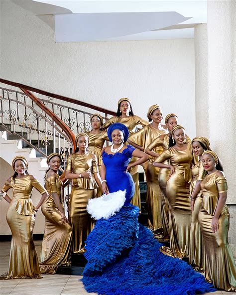 a group of women in gold and blue dresses standing next to each other on stairs