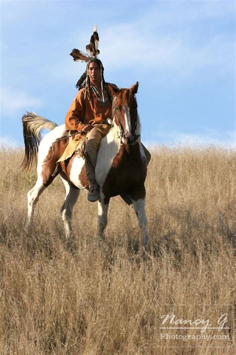 A Native American man on horseback riding the prairie of South Dakota. Nancy Greifenhagen ...