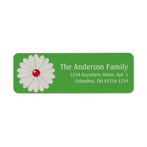 a green and white flower with a red center on the back of a return label