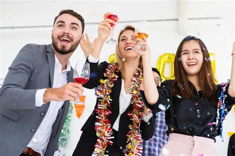 Premium Photo | Group of friends laughing celebrating holding flutes of champagne while dancing ...