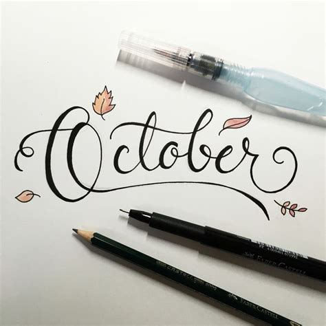 the word october written in cursive calligraphy with two pencils next to it