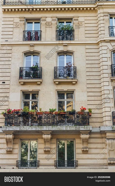 Old Paris Residential Buildings With Balconies And Flowers. Beautiful Facade Of Typical French ...