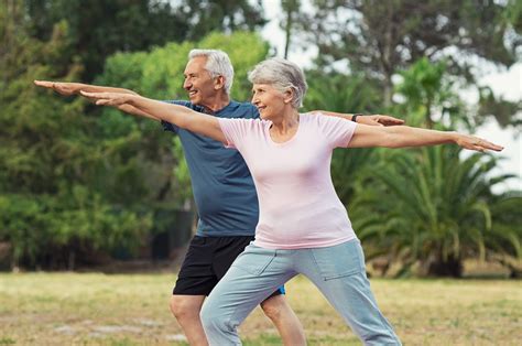 Old man and woman doing stretching exercise - Renaissance Villages