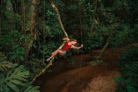 "Woman Swings From Vine In Jungle" by Stocksy Contributor "HOWL" - Stocksy