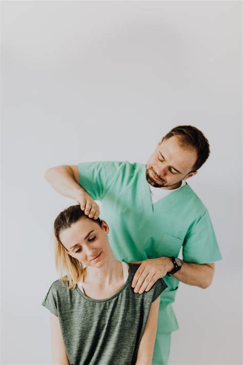 Content massage therapist doing neck massage on female patient · Free Stock Photo