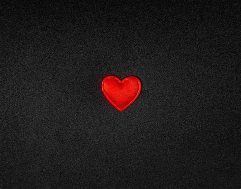 Premium Photo | Red heart on a black background of fabric