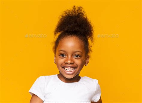 Portrait of african little girl smiling over yellow background Stock ...