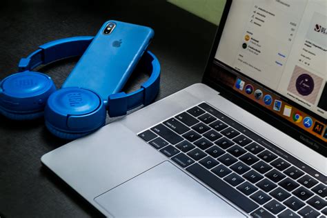 Macbook Pro Beside Blue Wireless Headphones · Free Stock Photo