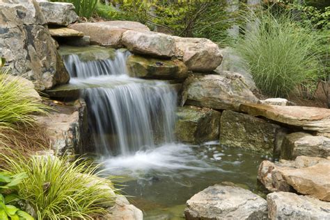 A simple, cheap way to build outdoor waterfalls is to erect cascading stone spillways that hang ...