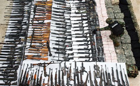 Mexican Marine standing in front of captured weapons From the Cartels ...