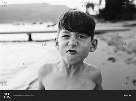 Portrait of a boy standing on a beach stock photo - OFFSET