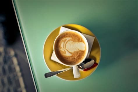 Coffee Latte on Saucer Beside Spoon · Free Stock Photo