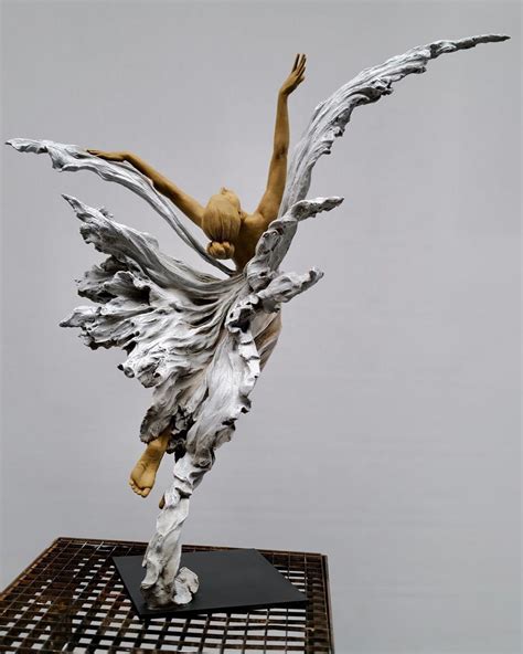 a sculpture of a woman with wings on top of a table