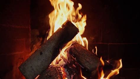 a fire burning in a fireplace with lots of logs sticking out of it's sides