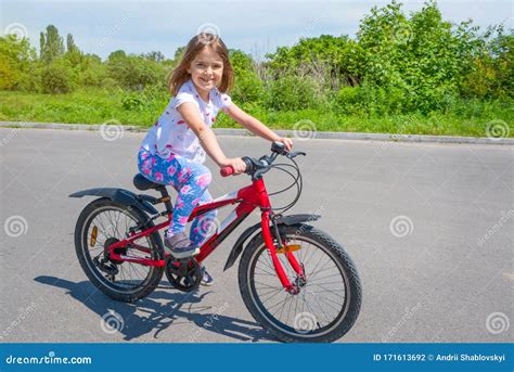 Happy Little Girl Riding Her Bike in the Park. the Concept of a Healthy Lifestyle Stock Photo ...