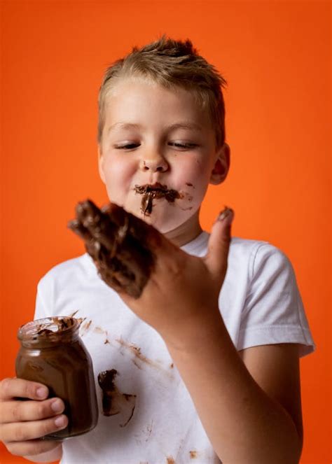 Boy in White Crew Neck T-shirt Holding Chocolate Jar · Free Stock Photo