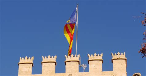 blue sky national flag waving on valencia silk exchange 4k spain 1296441 Stock Video at Vecteezy