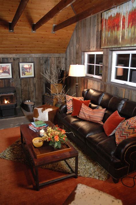 a living room filled with furniture and a fire place in the corner on top of a wooden wall