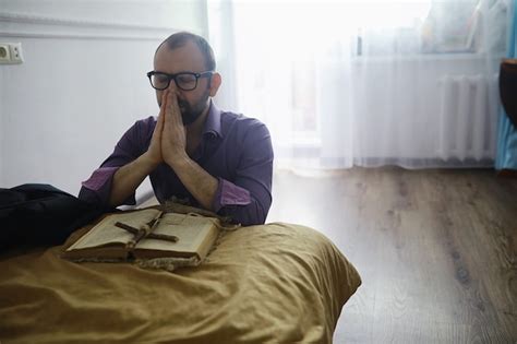 Premium Photo | Man reading and pray from the holy bible near the bed ...