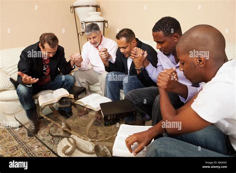 A Group Of Men Praying Together Stock Photo - Alamy