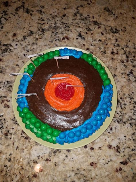 a cake with chocolate icing and candy on it in the shape of a circle